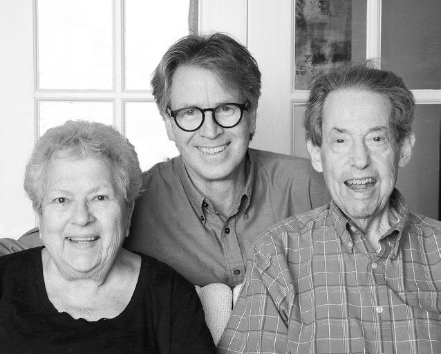 Joyce Siegel, Paul Tukey and Alan Siegel, seated together and smiling